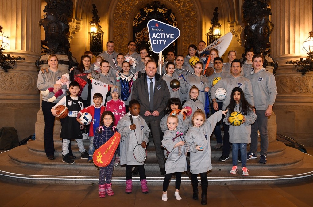 Hamburg politicians in charge of sports delivery pictured with a group of young sports players from the city.