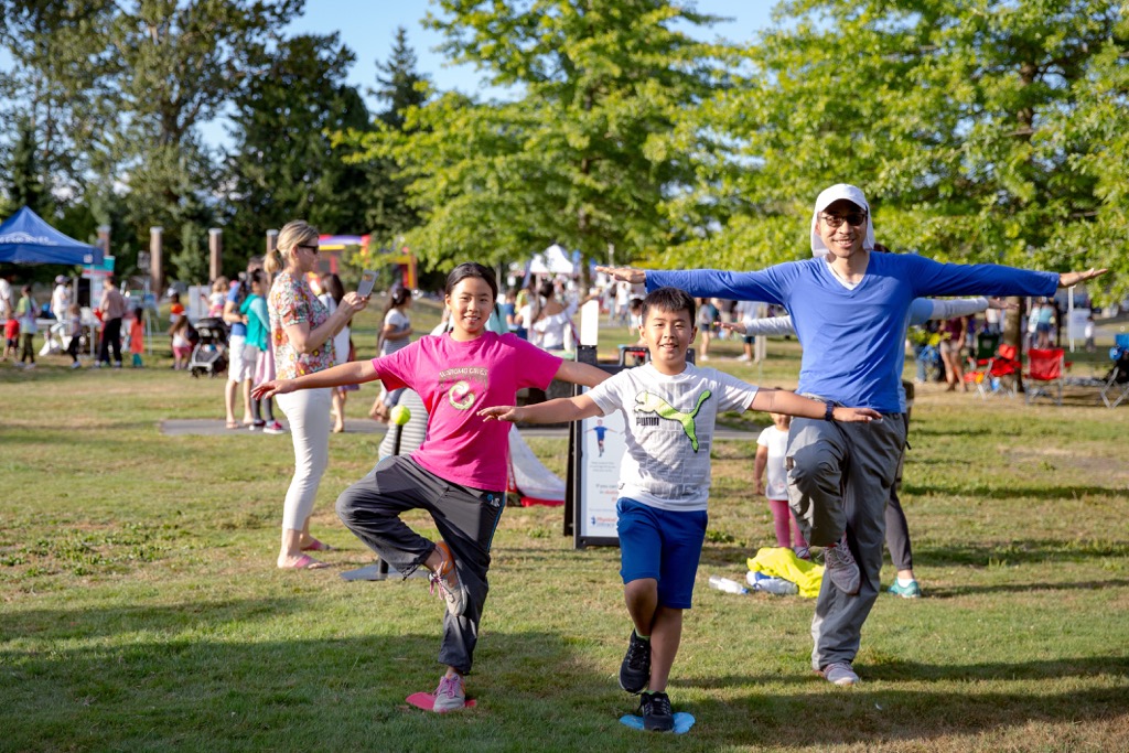 Adults and children take part in exercise classes in the park.